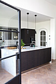 Modern kitchen with dark wooden cupboards and marble worktop