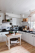 Country kitchen with white cabinets, black handles and black worktop