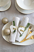 Golden cake forks and Christmas table decorations with heart pendants and glitter baubles