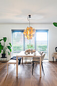 Dining area with wooden floor, plant and modern pendant light