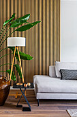 Modern living room with tripod lamp and wooden wall paneling