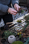 Person making wreath with natural materials