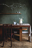 Rustic wooden table with teapot, cake and decorative bunny in the dining room