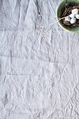 Ceramic bowl with quail eggs on linen cloth