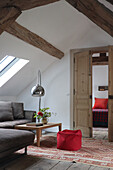 Attic living room with arched light and red pouf