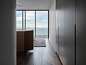 Wooden floor and large glass front in room with sea view