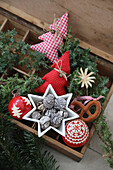 Wooden box with red and white Christmas decorations, star bowls, cones and baubles