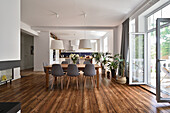 Open-plan dining area with large windows and wooden floorboards