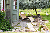 Deckchair in the rustic garden next to an open wooden shed