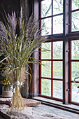 Dried ornamental grass in front of wooden mullion window