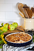 Apple tart with almonds on a chequered cloth in the kitchen