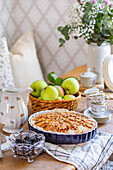 Apple pie on a laid table with flower arrangement