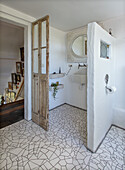 Badezimmer mit Mosaikfliesen und antiker Holztür