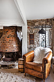 Leather lounge chair and rustic fireplace in the cosy living room