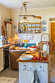 Country house kitchen with wooden furniture and vintage decor, basket full of plums