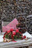 Christmas table decoration with Advent wreath and cones on a wooden table in the garden