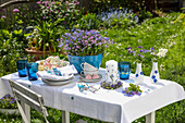 Table in the garden with spring decorations in shades of blue
