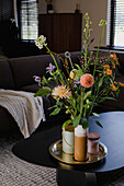 Blumenarrangement auf schwarzem Couchtisch