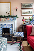 Fireplace with Delft tiles, rocking chair and red sofa in the living room