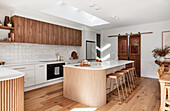 Modern kitchen with wooden fronts and kitchen island with bar stools