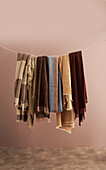 Various blankets in earth tones hanging on linen