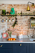 Rustic kitchen with brick wall, blue base unit and Christmas decorations