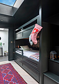 Children's room with dark green bunk bed and red carpet runner