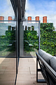 Modern terrace with glass wall and vertical garden