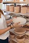 Pottery workshop with unglazed ceramic pots on shelves