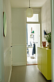 Flur mit gelbem Sideboard und hängender Deckenleuchte