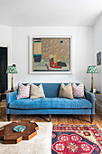Blue sofa with patterned cushions and abstract artwork in the living room