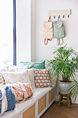 Light-coloured cushions and bags with block print patterns on a white bench