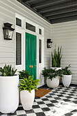 Entrance area with green front door, chequerboard tiles and white planters