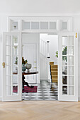 White-painted double doors with a view of the hallway and staircase