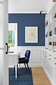 Desk in the study with blue accent wall and carpet