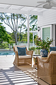 Covered terrace with rattan furniture and pool view