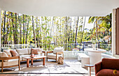 Modern terrace with wooden furniture and bamboo planting