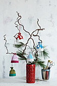 Branches with colorful winter hats made from corrugated cardboard as ornaments