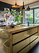Kitchen island with brass look and space motif on the wall