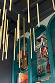 Modern bookcase, golden hanging lamps and decorative elements