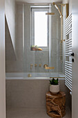 Modern bathroom with bathtub and golden fittings