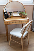 Dressing table with curved mirror and rattan details in bedroom