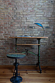 Old building room with stucco, chandelier and wooden table in front of a brick wall