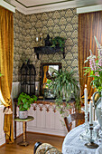 Living room corner with baroque wallpaper pattern and indoor plants