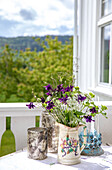 Wildblumenstrauß in verzierter Vase auf heller Veranda im Sommer