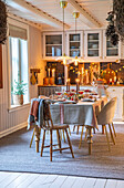 Festively laid dining table with linen tablecloth in cosy country house style