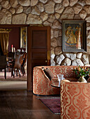 Colonial-style residence with natural stone walls, sofas and dining table