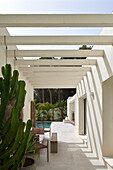 Modern terrace area with white pergola and views of the pool and palm trees