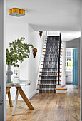 Entrance area with wooden staircase and striped carpet runner