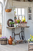 Spring table decoration with flowers and decorative bunnies on the veranda